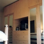 This armoire is made out of maple, the mirror doors with a maple frame are hung on concealed hinges. Behind the doors is a chrome pole for hanging clothes, a flat shelf for shoes and under the shelf are # 4 drawers. The middle section has #6 large drawers,an area for nick nacks or TV with lots of storage.