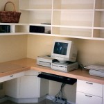This L shaped home office has white lacquered cabinets and a maple top. Included is a computer station and an area for writing. To the left of the writing area are a cabinet with four file drawers, two of them locking. The upper book shelf has lots of room for books.